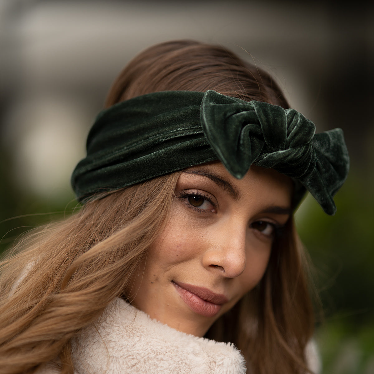 Mujer usando banda con moño color verde esmeralda