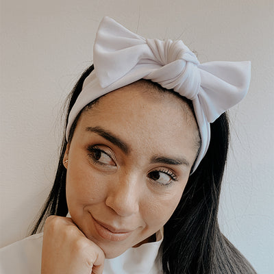 Mujer con balaca de tela con moño blanco