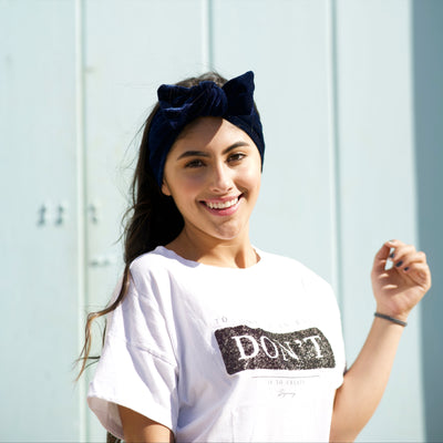 Modelo usando banda con moño para el cabello en terciopelo azul